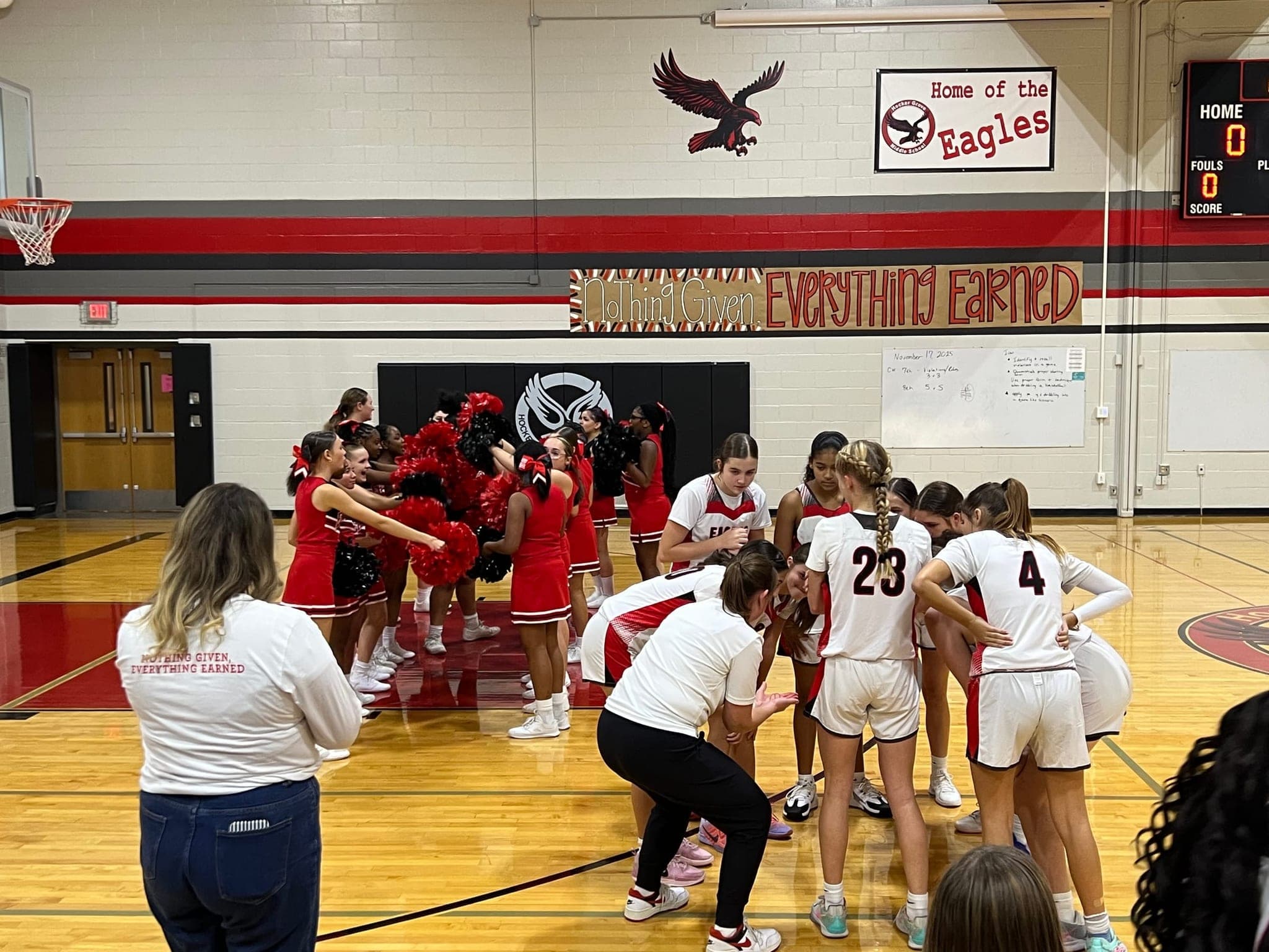 A girls basketball team gathering with their coach